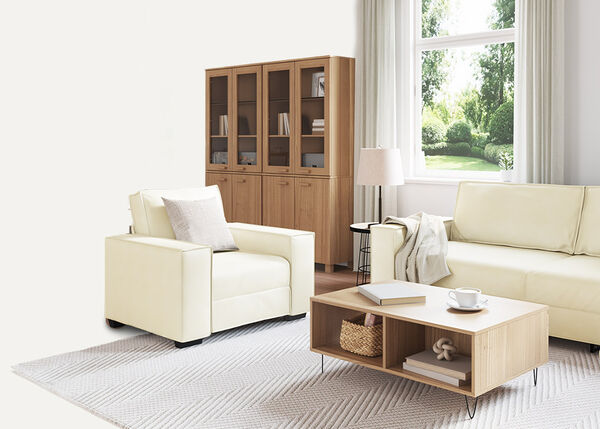 Valge kahekohaline diivan koos padjade ja tekiga, siseruumides.